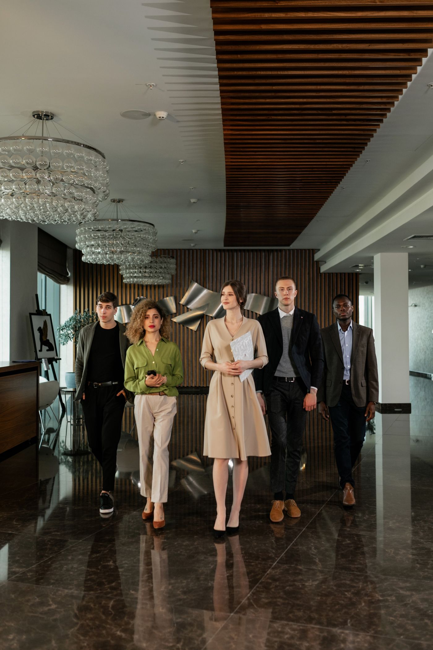 Three colleagues walk together through a modern workplace hallway.