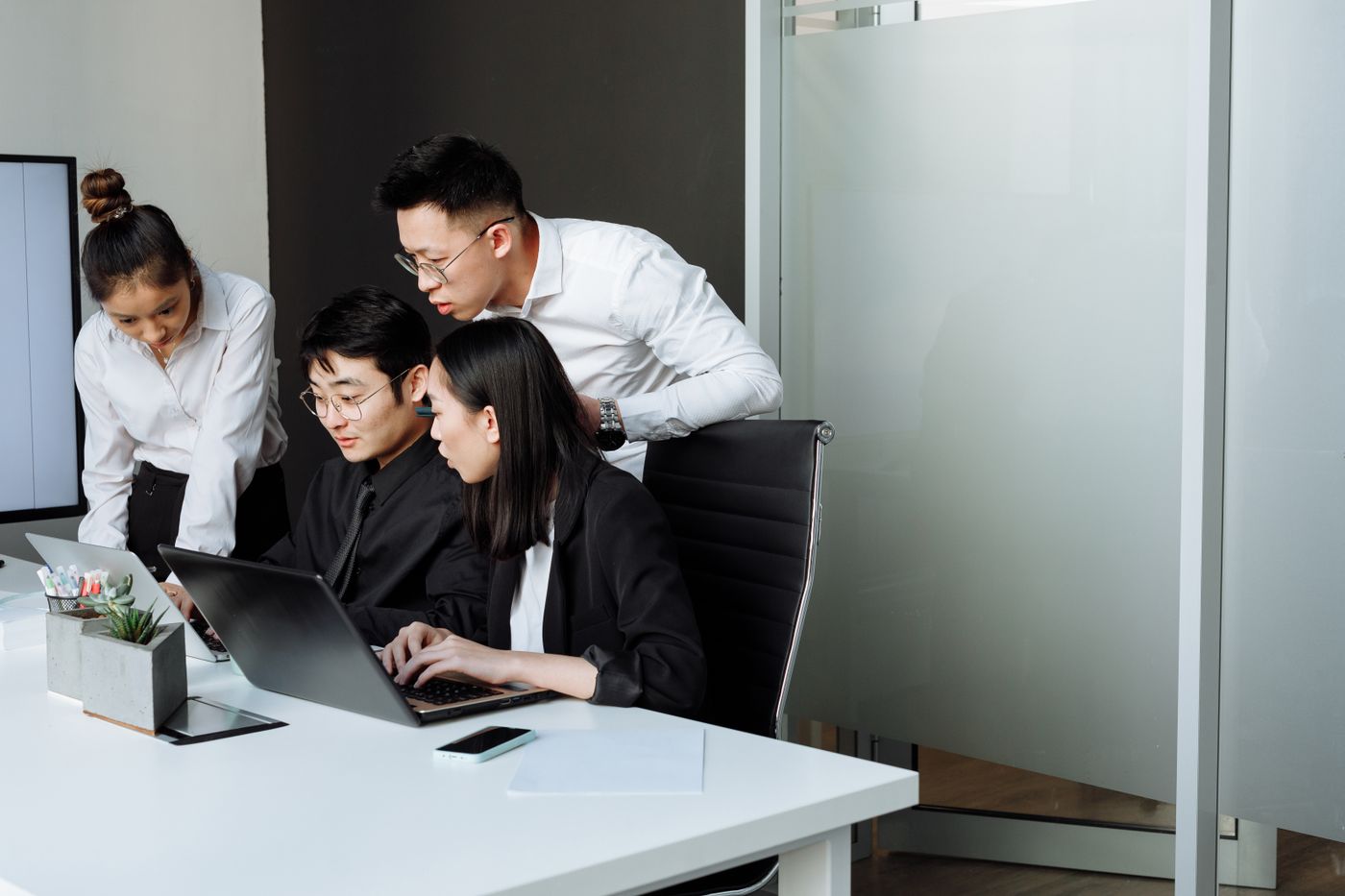 Workplace team discussing documents around a meeting table.