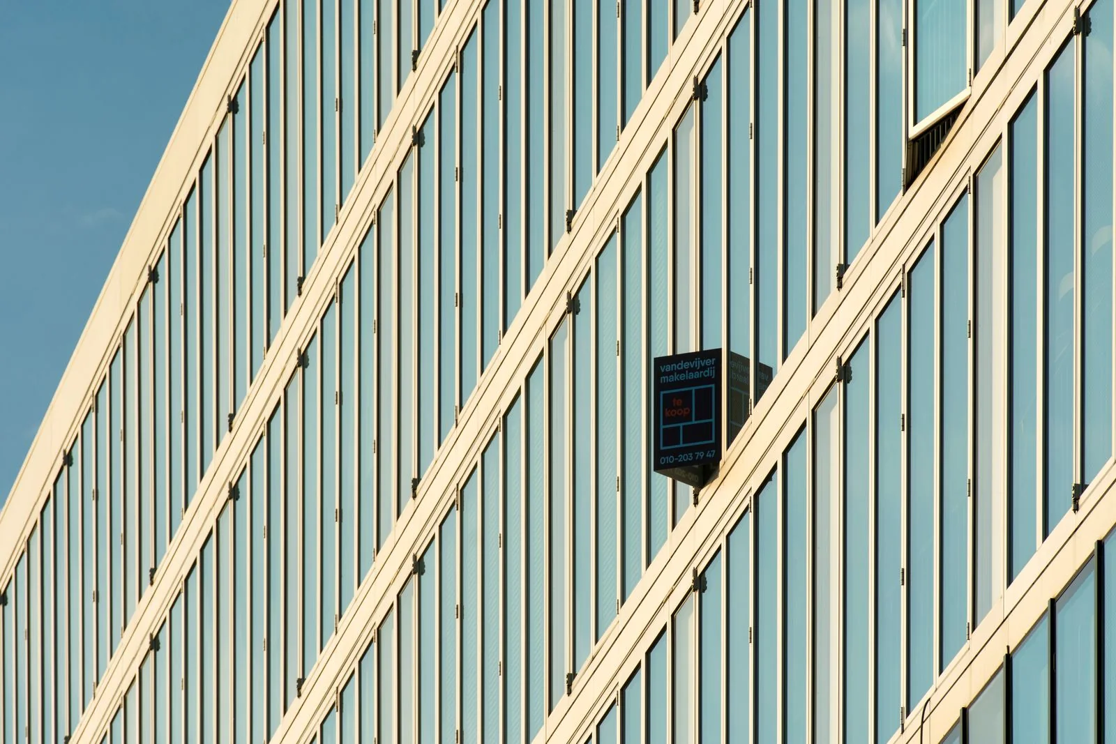 Diagonal rows of glass office windows framed by white structural bands.