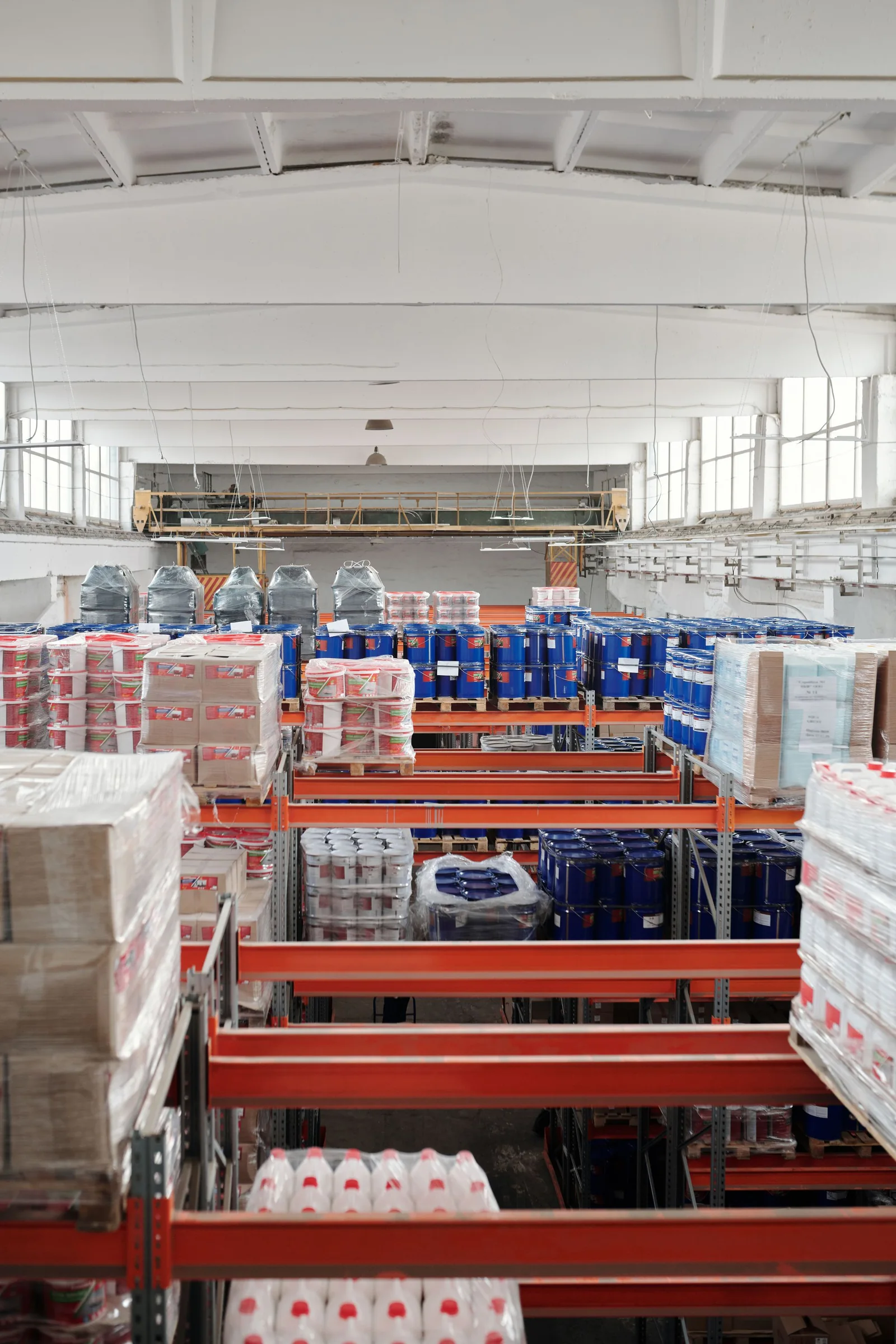 Industrial warehouse interior with tall storage racks and organized goods.